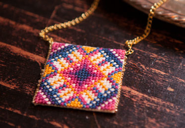 Anna Maria makes cross-stitch modern with this pendant, worked up in one of her signature bright palettes. The small scale makes this project terrific for new cross stitchers.